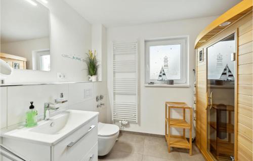 a white bathroom with a sink and a toilet at Puettenhuus in Tossenserdeich