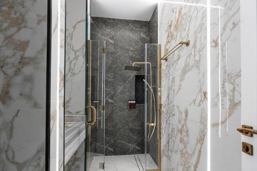 a shower with a glass door in a bathroom at La Maison Resort in Doha