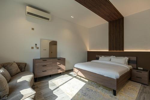 a bedroom with a bed and a couch at La Maison Resort in Doha