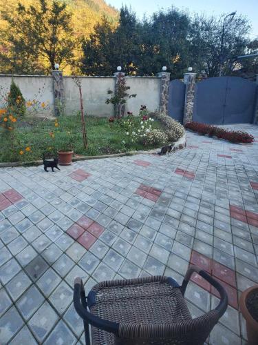 two cats sitting on a patio with a chair at DIOSKURIA BORJOMi in Borjomi