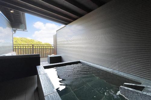 a swimming pool in the side of a house at 鵜原館 -Ubarakan- in Katsuura