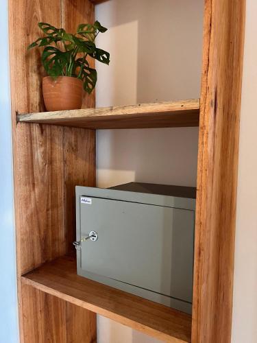 a wooden shelf with a microwave on it at Amaroo Hikkaduwa in Hikkaduwa