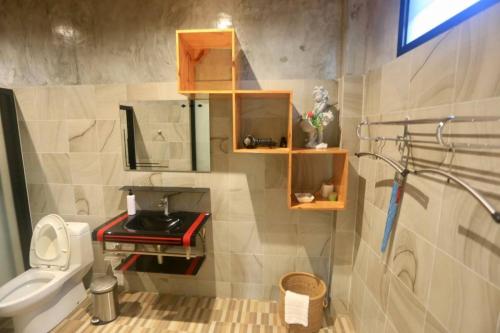 een kleine badkamer met een toilet en een wastafel bij ปลายน้ำรีสอร์ท พรหมคีรี นครศรี ฯ Plainam Resort in Ban Khaek