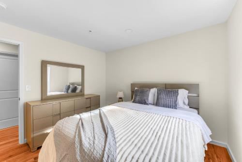 um quarto branco com uma cama e um espelho em Cozy 3BR Newark Apt with Easy Access to NYC and Seton Hall em Newark