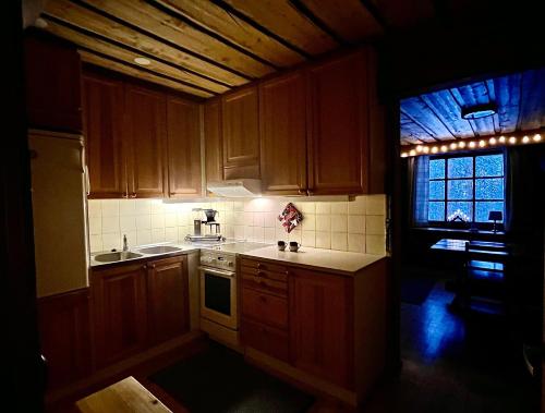 uma pequena cozinha com armários de madeira e uma janela em Arctic Lodges Lapland Ski in, slopes, ski tracks, National Park, free Wi-Fi - Lapland Villas em Pyhätunturi