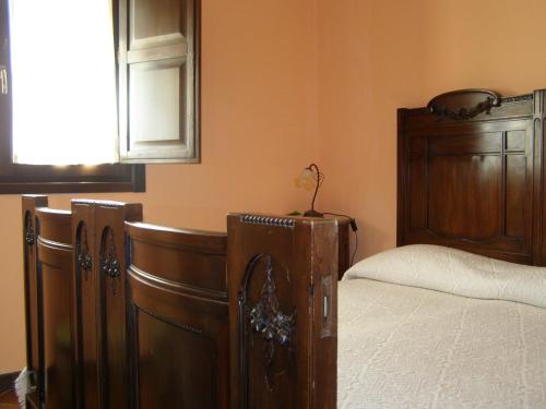 a bedroom with a bed and a wooden foot board at B&B Le Grazie in Piaggine