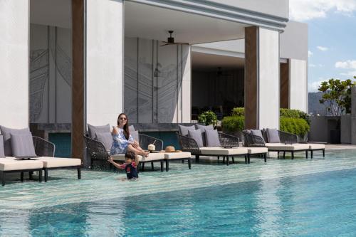 a woman and a child sitting in a swimming pool at Courtyard by Marriott Phuket Town in Phuket
