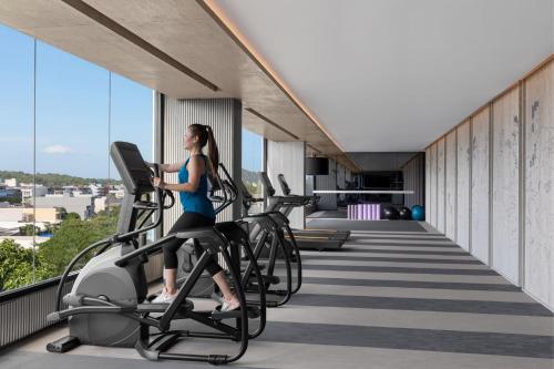 a woman riding on a treadmill in a gym at Courtyard by Marriott Phuket Town in Phuket