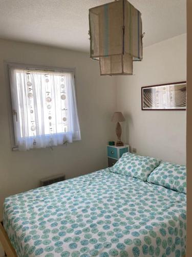 une chambre avec un lit et une fenêtre dans l'établissement L'appartement de la Garenne, à Carnac