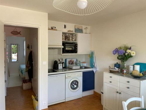 une cuisine avec une cuisinière et une machine à laver dans l'établissement L'appartement de la Garenne, à Carnac