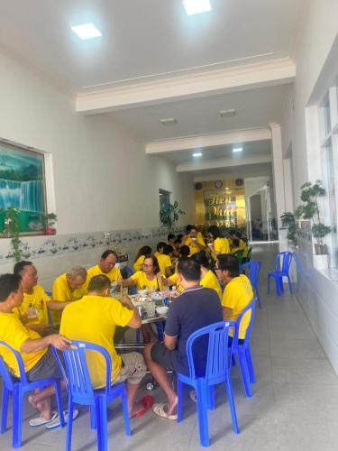 a group of people in yellow shirts sitting at a table at Motel Tiến Phúc in Long Hai