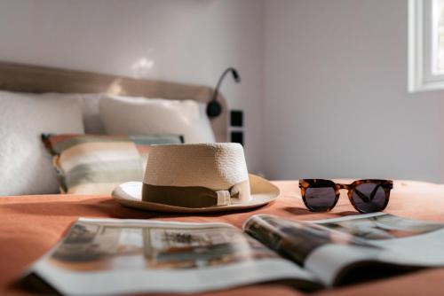 kapelusz i okulary słoneczne siedzące na stole w obiekcie Chalet Hockslee w mieście Goebelsmuhle