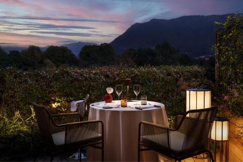 a table with wine glasses and a view of a field at Sheraton Lake Como Hotel in Como