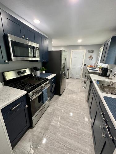 a kitchen with black cabinets and a stove top oven at Notre Dame vs USC, 5 BR Ranch Walk to Campus, 2 Full Baths, Game Room in South Bend