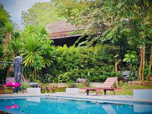 una piscina con un banco de madera junto a una casa en PM Hill villa, en Bophut 