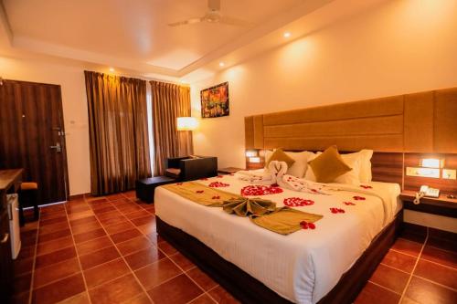 a bedroom with a large bed with red roses on it at Athirapally Green Trees in Athirappilly