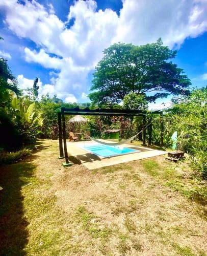 a swing around a swimming pool in a yard at Hermosa Nests in Playa Hermosa