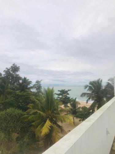 a view of a beach with palm trees and the ocean at Marakolliya Beach Resort in Tangalle
