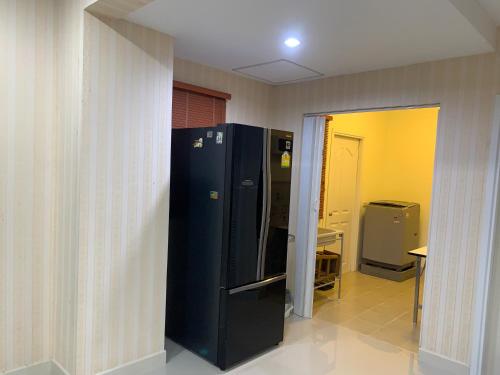 a black refrigerator in a room with a hallway at เดอะแพลนภัสสร in Ban Rong