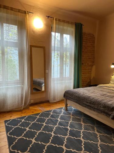 1 dormitorio con cama, espejo y ventanas en World Studio Family Apartment, en Sibiu