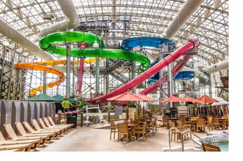 a water slide in a building with tables and chairs at Lux 5BR 4BA SV125 SKI In Out, 18-hole Championship Golf Course, Water Park, pet friendly in Jay