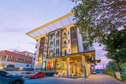 a building with cars parked in front of it at Korapura Resort in Nakhon Ratchasima