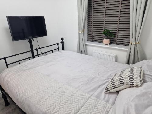 a bedroom with a bed and a flat screen tv at The place of peace in Saint Helens