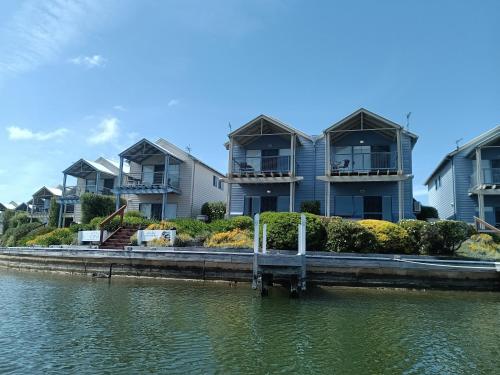a row of houses next to a body of water at Captains Cove Resort - Waterfront Apartments in Paynesville