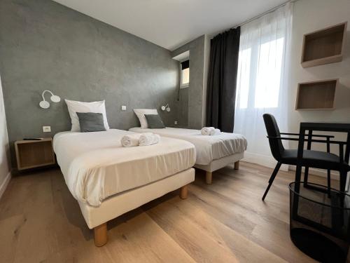 1 Schlafzimmer mit 2 Betten, einem Stuhl und einem Fenster in der Unterkunft Hôtel Ponson in Aubenas