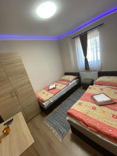 a room with two beds and a table in it at Aba - Böbe Vendégház in Zalaszentiván