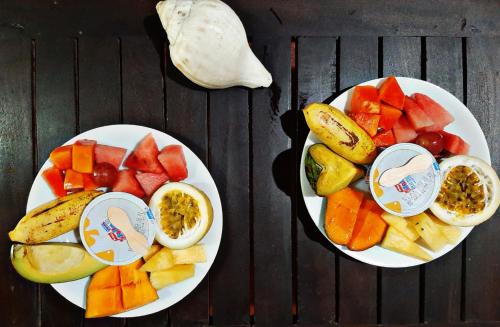 two white plates of fruit on a table at Villa Blue Ocean in Mirissa