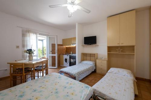 een kamer met 2 bedden en een keuken met een tafel bij Monolocale ingresso indipendente con corte esclusiva in Montemarciano