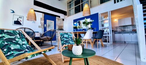un salon avec une table et des chaises dans l'établissement Le Tassigny, Duplex Superbe Vue sur les Quai, Centre Historique, à Sète