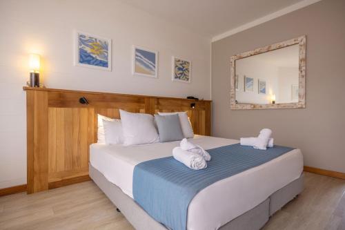 a bedroom with a large bed with towels on it at Hotel Le Boucan Canot in Saint-Gilles-les-Bains