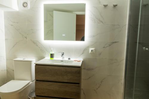 a bathroom with a sink and a toilet and a mirror at Rooms Luxury Madrid in Madrid