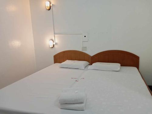 Una cama con dos almohadas blancas encima. en WJV INN JY, en Cebú