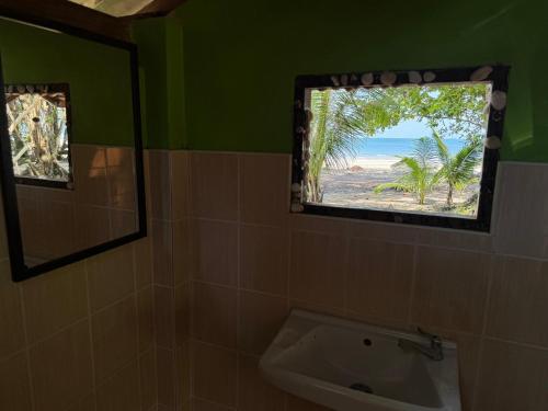 a bathroom with a window with a view of the beach at Changthong Bungalow in Koh Chang Ranong