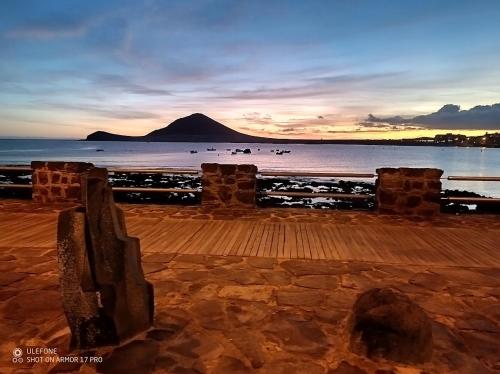a view of the ocean with a mountain in the background at Médano Dreams in El Médano
