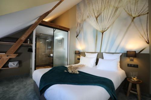 a bedroom with a large bed and a large window at Hôtel-SPA Le Moulin De La Wantzenau - Strasbourg Nord in La Wantzenau