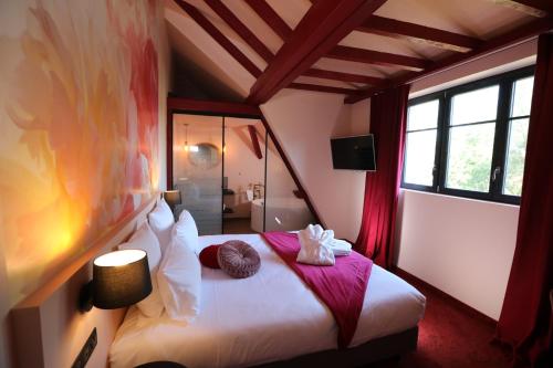 a bedroom with a bed with two towels on it at Hôtel-SPA Le Moulin De La Wantzenau - Strasbourg Nord in La Wantzenau