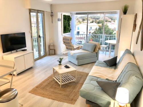 a living room with a couch and a tv at Le Brusc. Design, Parking, Wifi & Double Vue! in Six-Fours-les-Plages