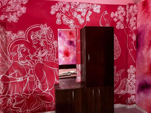 une salle de bains avec un mur rouge orné d'une peinture. dans l'établissement SANTA MARIA HOSTEL MUNROE ISLAND, à Munroe Island