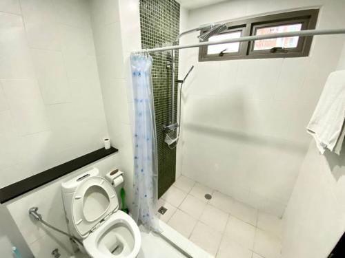 een kleine badkamer met een toilet en een douche bij The Urban Pattaya in Pattaya