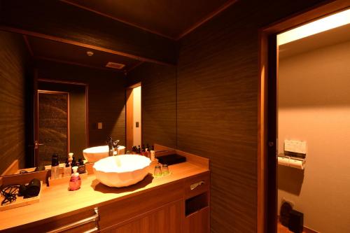 a bathroom with a sink and a large mirror at 鵜原館 -Ubarakan- in Katsuura