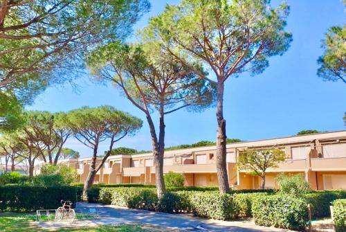 a building with trees in front of it at IssTravel, Holiday Homes in Marina di Bibbona from 400 to 900 meters from the sea, apartments 6 beds with private outdoor area in Marina di Bibbona