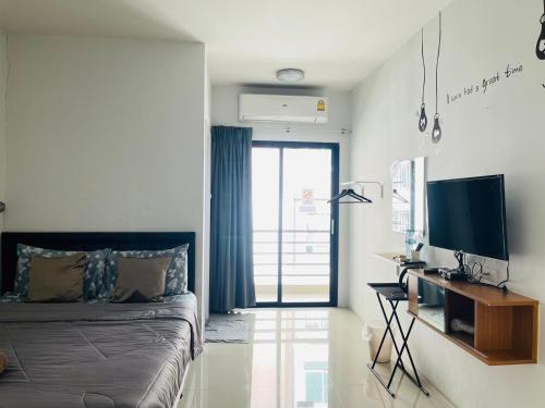 Schlafzimmer mit einem Bett und einem Schreibtisch mit einem TV in der Unterkunft HOMEY-Don Mueang Airport Hostel in Bangkok