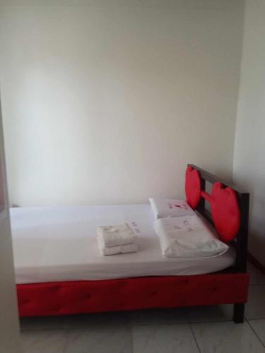 uma pequena cama num quarto com almofadas vermelhas em WJV INN JY em Cebu