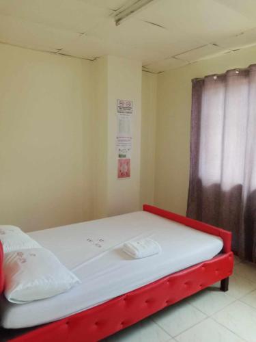 a bed with a red frame in a room at WJV INN JY in Cebu City