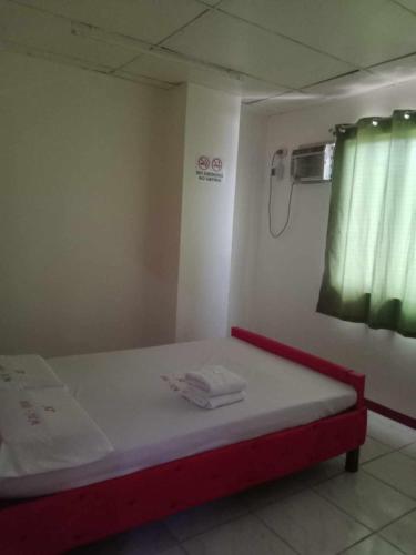 uma cama num quarto com uma janela verde em WJV INN JY em Cebu