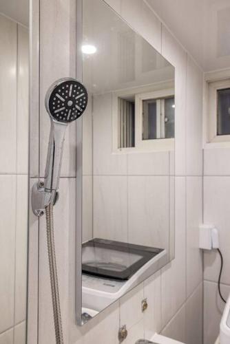 a shower head in a bathroom with a mirror at Warm Place in Seoul